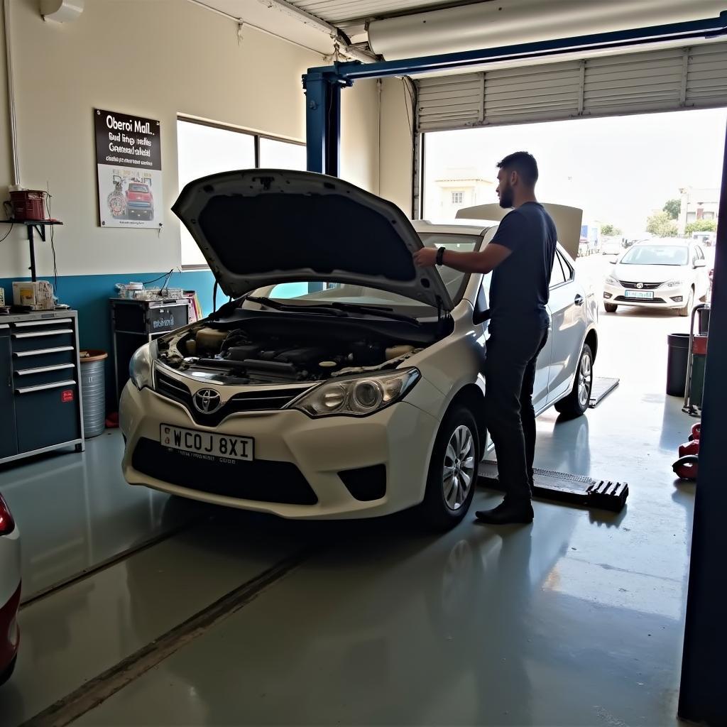 Mechanic repairing a car in a service centre near Oberoi Mall in Malad.